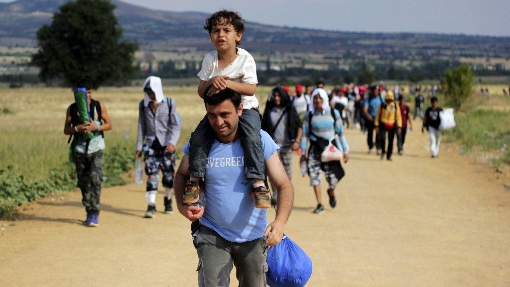 a_migrant_carries_a_child_as_t_08910000
